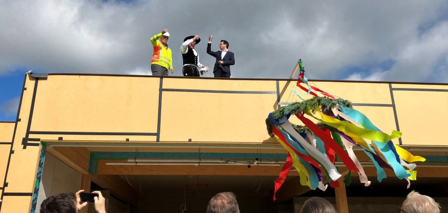 Bürgermeister Dr. Fadavian, Dachdeckermeister Michael Pütz und Bauleiter Bernd Bender (v.r.) auf dem Dach der Schwimmhalle beim Richtspruch