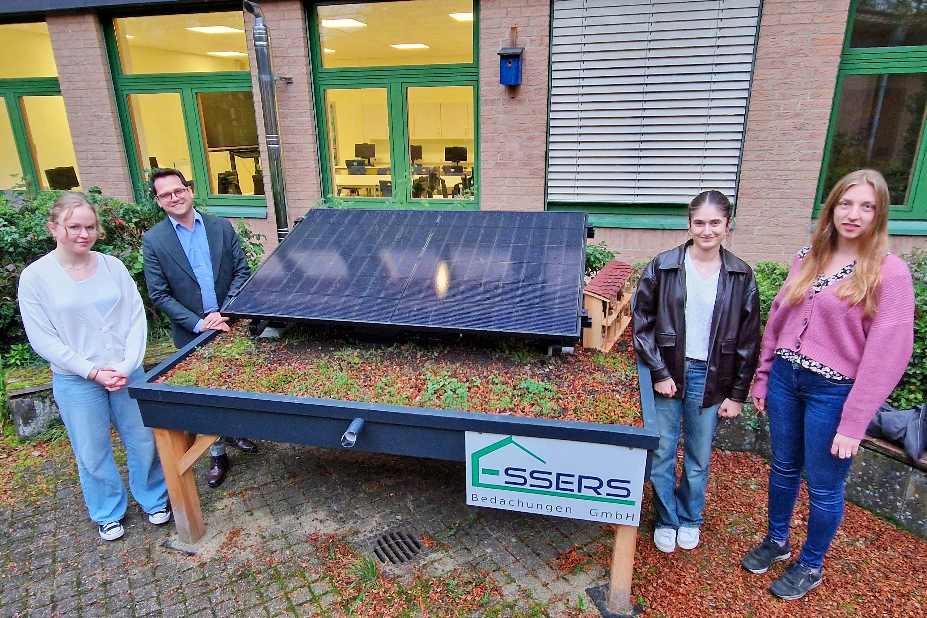 Bild der Balkonsolaranlage im Gymnasium mit Schülerin Pauline Hirschhausen, Bürgermeister Dr. Benjamin Fadavian, Schülerin Venus Masoudi und Fabienne Heinrichs von der Klima- und Umweltschutzabteilung der Stadt Herzogenrath (v.l.n.r.)