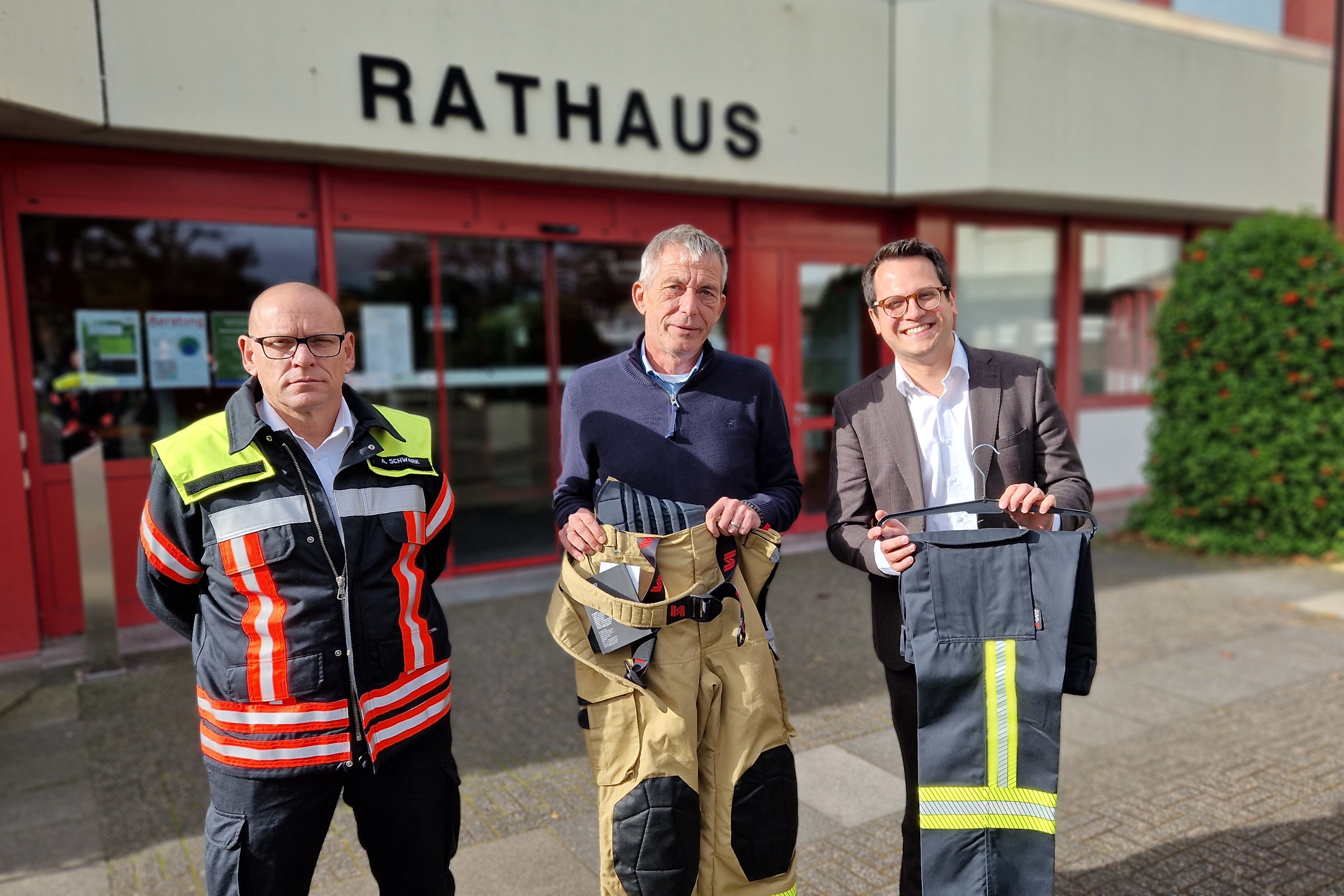 Gruppenbild mit Achim Schwark, René Günther und Dr. Benjamin Fadavian (v.l.n.r.), die die dank der Förderung der Provinzial neu angeschafften Feuerwehrhosen präsentieren