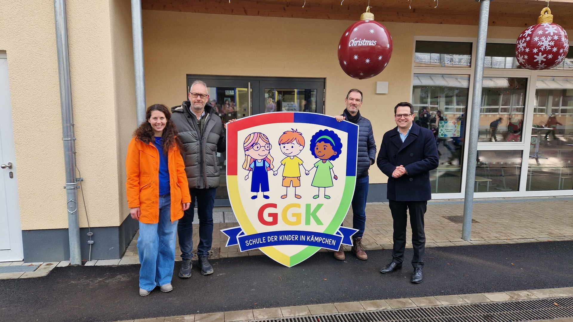 Das Gruppenbild zeigt v.l.n.r. Schulleiterin Heike Keller, Markus Müller als Vorsitzender des Ausschusses für Bildung und Schulbauangelegenheiten, den Technischen Beigeordneten Franz-Josef Türck-Hövener und Bürgermeister Dr. Benjamin Fadavian mit dem neuen Schullogo.