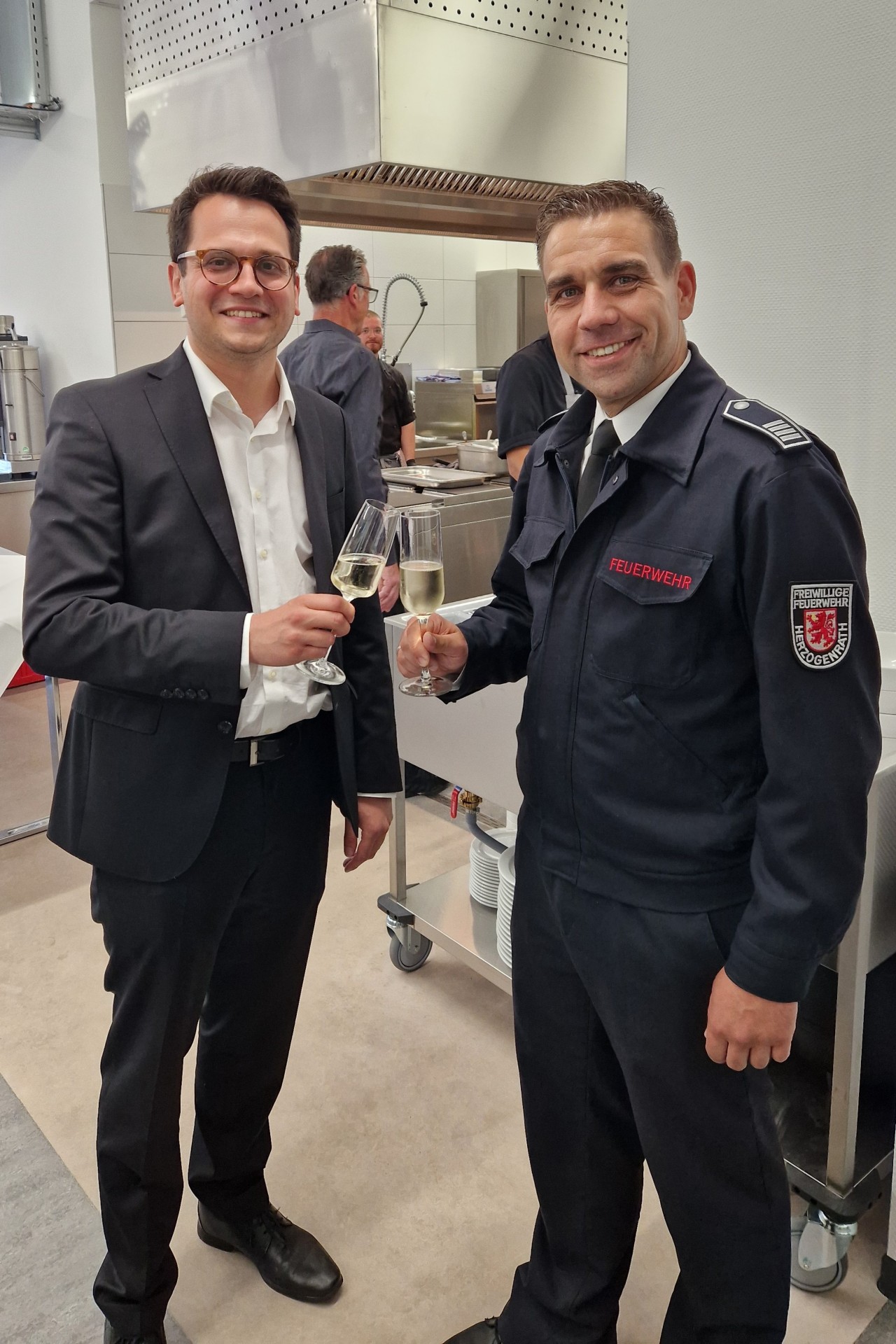 Dr. Benjamin Fadavian und Carsten Schütte stoßen auf den neuen Raum an