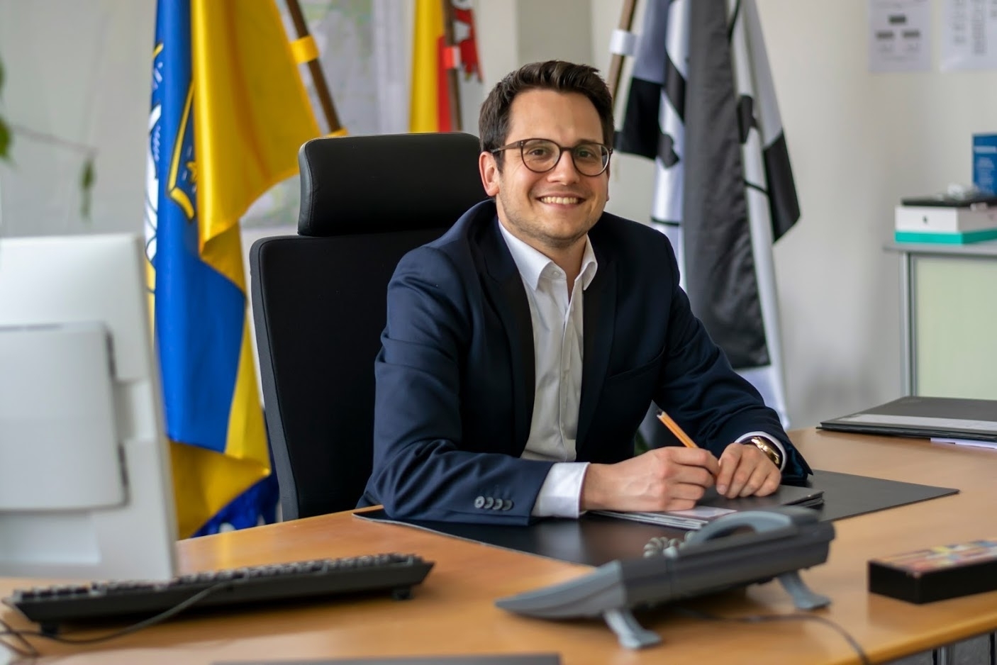 Auf dem Fot sieht man den Bürgermeister Dr. Benjamin Fadavian, der an seinem Schreibtisch sitzt.