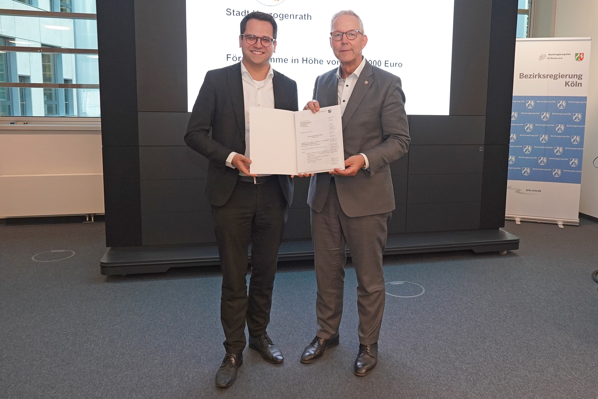 Bürgermeister Dr. Benjamin Fadavian mit Regierungspräsident Gregor Lange bei der Übergabe des Bescheids in Köln