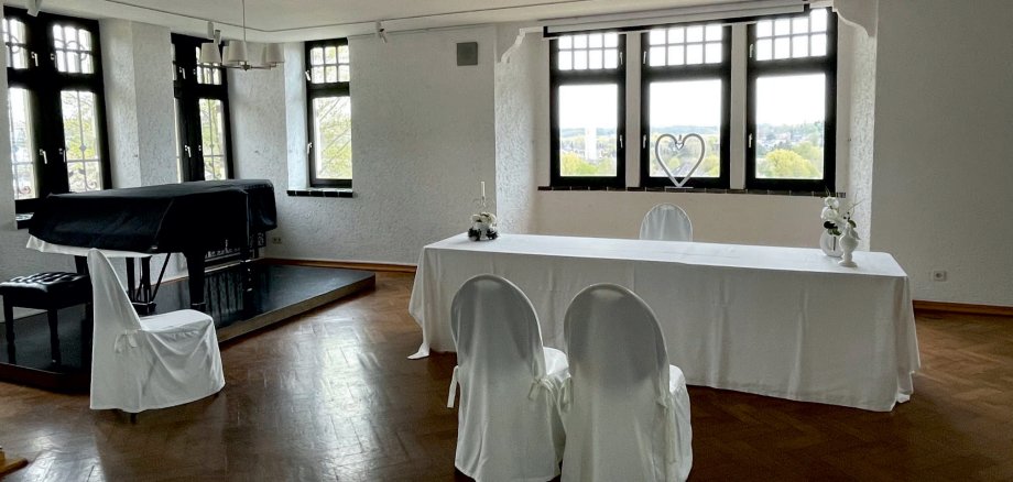 Foto: Heller Raum mit vielen Fenstern. Zwei Stühle stehen vor dem Trautisch