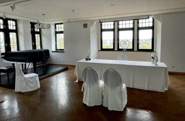 Foto: Heller Raum mit vielen Fenstern. Zwei Stühle stehen vor dem Trautisch