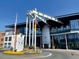 Foto: Vordere Seite des EBC Gebäudes Das Foto zeit den vorderen Bereich des EBC Gebäudes, welches sich durch die Glasfront und seine vorstehenden Stahlträger auszeichnen