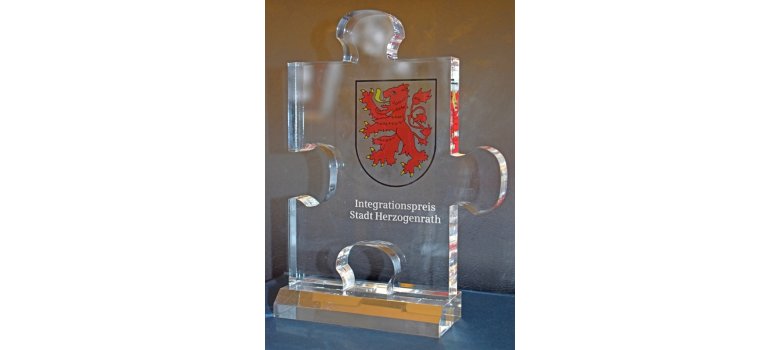 Integrationspreis Herzogenrath, Trophäe aus Glas, Puzzlestück mit Herzogenrather Wappen
